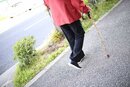 杖をついて歩いている人