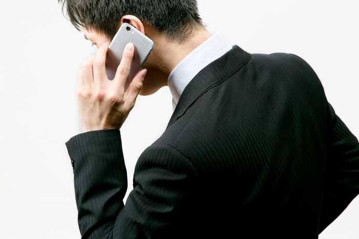 携帯電話をかけるスーツ姿の男性