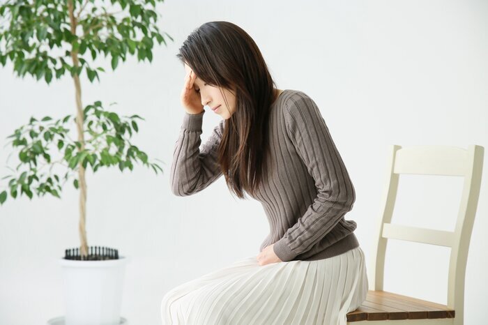 頭を押さえる女性